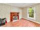 Bedroom with hardwood floors, a decorative fireplace, and a window providing natural light at 251 Charles Riddle Rd, Sanford, NC 27330