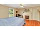 Bright bedroom featuring hardwood floors, a fireplace, and a ceiling fan at 251 Charles Riddle Rd, Sanford, NC 27330