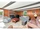 Cozy living room with wood-paneled walls, ceiling beams, and a brick fireplace at 251 Charles Riddle Rd, Sanford, NC 27330