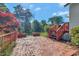 Brick patio with adjacent stairs leading to a wooden deck and views of landscaped foliage and blue skies at 251 Charles Riddle Rd, Sanford, NC 27330