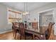 Elegant dining room with a wooden table, chairs, natural light, and hardwood flooring at 2690 Meadow View Ln, Sanford, NC 27332