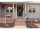 Inviting front porch with brick steps, a cozy seating area, and attractive decorations at 2690 Meadow View Ln, Sanford, NC 27332