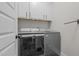 Functional laundry room with modern washer and dryer, plus storage cabinets above for added convenience at 2690 Meadow View Ln, Sanford, NC 27332