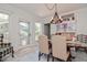 Dining area featuring natural light, a stylish chandelier, and a classic dining set, complemented by a cozy sitting area at 2717 Jack Rd, Clayton, NC 27520