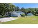 Exterior view of home showcasing a well-maintained lawn, detached garage, and a metal roof at 2717 Jack Rd, Clayton, NC 27520