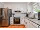 Well-lit kitchen showcasing stainless steel appliances, white subway tile backsplash, granite counters and hardwood floors at 2717 Jack Rd, Clayton, NC 27520