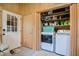 Mud room with stacked laundry machines and a storage shelf above for organizing supplies at 2717 Jack Rd, Clayton, NC 27520