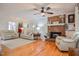Spacious living room with hardwood floors, a brick fireplace, neutral furniture, and a ceiling fan at 2717 Jack Rd, Clayton, NC 27520