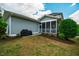 This backyard features a grill, gray siding, grass lawn, and a screened in porch at 281 N Serenity Hill Cir, Chapel Hill, NC 27516