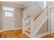 Bright entryway featuring hardwood floors, a staircase with white railings, and a view of the front door at 281 N Serenity Hill Cir, Chapel Hill, NC 27516