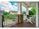 Inviting front porch with stone columns, white railing, wooden floors, and Adirondack chairs for relaxing at 281 N Serenity Hill Cir, Chapel Hill, NC 27516