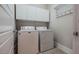 A well-organized laundry room featuring a washer, dryer, overhead cabinets, and a convenient coat rack at 281 N Serenity Hill Cir, Chapel Hill, NC 27516