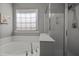 Bright bathroom features a soaking tub with a shower and large window at 2812 Prospect Pkwy, Durham, NC 27703