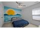 Cheerful bedroom with an eye-catching mural, ceiling fan, and bright window at 2812 Prospect Pkwy, Durham, NC 27703