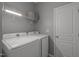 Well-equipped laundry room with modern washer and dryer units and storage shelves at 2812 Prospect Pkwy, Durham, NC 27703