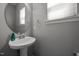 Stylish powder room featuring a pedestal sink, modern faucet, and decorative mirror at 2812 Prospect Pkwy, Durham, NC 27703