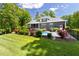 Backyard with pool, lush landscaping, grey siding, screened porch and outdoor living at 30 Ocoee Falls Dr, Chapel Hill, NC 27517