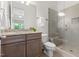 Well-lit bathroom with granite counters, wood cabinets, and tiled glass shower at 30 Ocoee Falls Dr, Chapel Hill, NC 27517