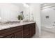 Well-lit bathroom with double vanity, granite countertop, and tiled shower and bathtub at 30 Ocoee Falls Dr, Chapel Hill, NC 27517