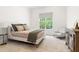 Bright bedroom features a comfy bed, neutral color palette, and a window with leafy views at 30 Ocoee Falls Dr, Chapel Hill, NC 27517