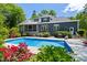 Backyard swimming pool with patio, beautiful landscaping, and a dark colored house at 30 Ocoee Falls Dr, Chapel Hill, NC 27517