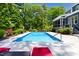 Beautiful pool area featuring a rectangular pool, red lounge chairs, and lush landscaping surrounding the pool at 30 Ocoee Falls Dr, Chapel Hill, NC 27517