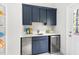 Pool house wet bar featuring blue cabinets, stainless steel appliances, white quartz countertops, and storage shelves at 30 Ocoee Falls Dr, Chapel Hill, NC 27517