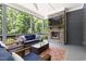 Screened in porch featuring a fireplace, TV, and comfortable seating with scenic wooded views at 30 Ocoee Falls Dr, Chapel Hill, NC 27517