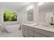 Bright bathroom showcasing a soaking tub, double vanity, and a picture window at 300 Livingstone Dr, Cary, NC 27513