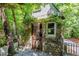 Exterior view of a stone shed nestled among lush trees and landscaping at 300 Livingstone Dr, Cary, NC 27513