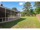 Backyard featuring a screened-in porch, well-manicured lawn, and a wood fence at 305 E Holmes St, Benson, NC 27504