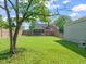 Wide shot of large backyard with screened porch, house, garage and mature tree at 305 E Holmes St, Benson, NC 27504