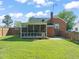 Back view of a brick house with a screened-in porch and spacious backyard at 305 E Holmes St, Benson, NC 27504