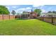 Spacious backyard surrounded by a wood fence with grass lawn and screened in porch at 305 E Holmes St, Benson, NC 27504