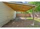 Open backyard with a covered area and wooden fence at 305 E Holmes St, Benson, NC 27504