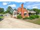 Charming red brick home with manicured landscaping and a detached two-car garage at 305 E Holmes St, Benson, NC 27504