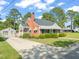 Side angle view of a brick home with manicured landscaping and detached garage at 305 E Holmes St, Benson, NC 27504
