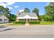 Charming single-story brick home featuring a cozy front porch and well-maintained landscaping at 305 E Holmes St, Benson, NC 27504