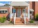 Close up of brick front porch featuring brick steps, white railings, and awning at 305 E Holmes St, Benson, NC 27504