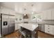 Eat-in kitchen includes white cabinetry, stainless appliances, gray countertops and central island at 305 E Holmes St, Benson, NC 27504