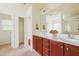 Double sink bathroom with cherry cabinets, a large mirror, and natural light at 306 Mainline Station Dr, Morrisville, NC 27560