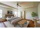 Spacious staged main bedroom with trey ceilings, a ceiling fan, a bench, a king bed and neutral decor at 306 Mainline Station Dr, Morrisville, NC 27560