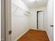 Walk-in closet featuring wood-look floors, storage shelving, and a door to the bedroom at 306 Mainline Station Dr, Morrisville, NC 27560