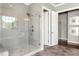 A modern bathroom featuring a glass-enclosed shower with river rock floor, a large window, and white doors at 318 Ivy Ridge Rd, Chapel Hill, NC 27516