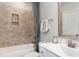Elegant bathroom featuring neutral tile in shower, white vanity and toilet, and natural light from a window at 318 Ivy Ridge Rd, Chapel Hill, NC 27516