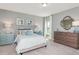 Cozy bedroom features a neutral color scheme with pops of teal, a large dresser, and ample natural light at 318 Ivy Ridge Rd, Chapel Hill, NC 27516