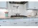 Close-up of kitchen with stainless steel appliances, white cabinets, and stylish backsplash at 318 Ivy Ridge Rd, Chapel Hill, NC 27516