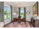 Bright office space featuring a dark wood desk, modern light fixture, and views of the green exterior at 318 Ivy Ridge Rd, Chapel Hill, NC 27516