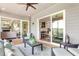 Relaxing outdoor patio with comfortable seating, ceiling fan, and sliding glass doors to the interior at 318 Ivy Ridge Rd, Chapel Hill, NC 27516