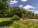 Well-maintained lawn with mature trees and manicured landscaping at 3403 Raccoon Run Dr, Burlington, NC 27215